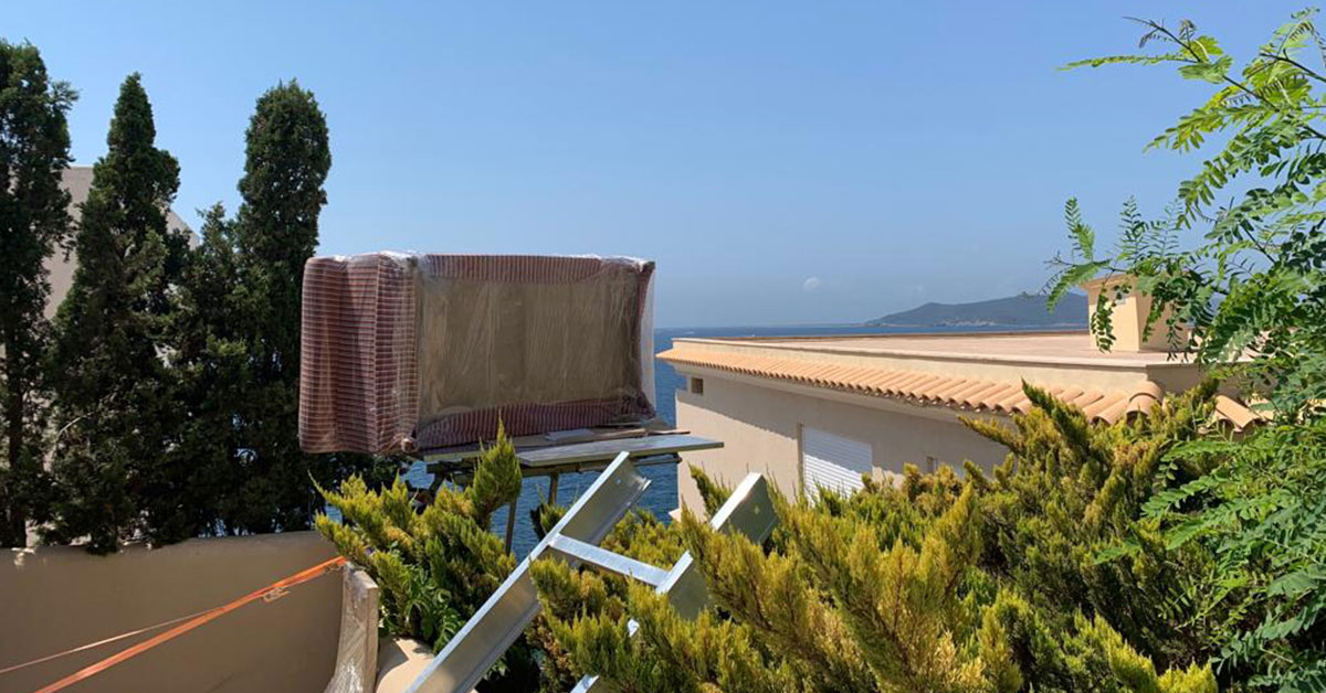Plataforma elevadora transportando un sofá durante una mudanza en Ibiza